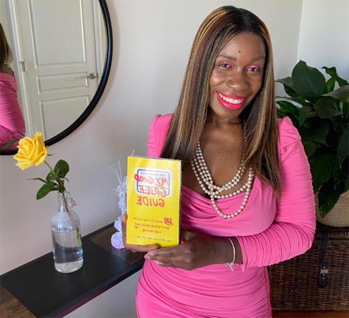 A person holding a book titled "My Good Grief Guide"